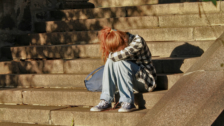 Mädchen weinend auf einer Treppe