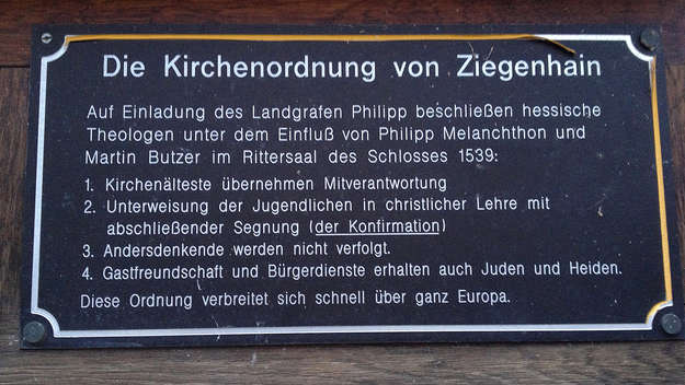 Schwarze Gedenktafel an der Schlosskirche in Ziegenhain/Schwalmstadt im Schwalm-Eder-Kreis in Hessen, die an die Einführung der Konfirmation im Jahre 1539 erinnert