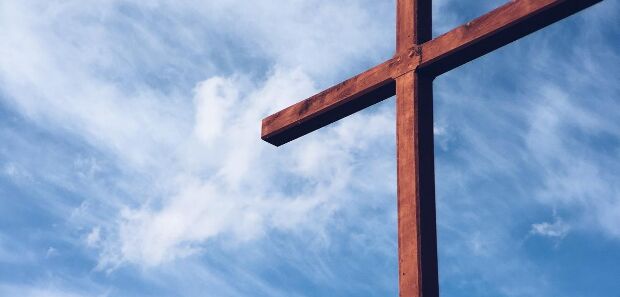 Holzkreuz vor blauem Himmel