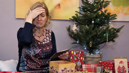 Verärgerte Frau neben dem Weihnachtsbaum(gestelltes Foto)