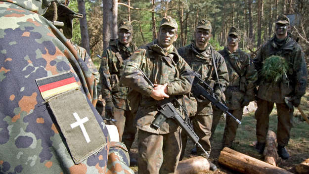 Mahaufnahme der Schulterklappe einers evangelischen Militärpfarrers, der Rekruten einer Panzertruppenschule bei einer Übung im Gelände besucht.