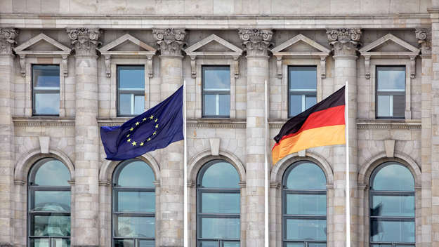 Eine europäische und eine deutsche Flagge wehen vor dem Bundestag in Berlin.