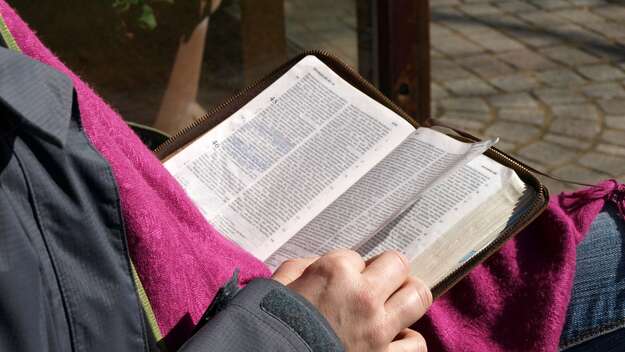 Symbolbild: Ein Mensch liest in einer Bibel
