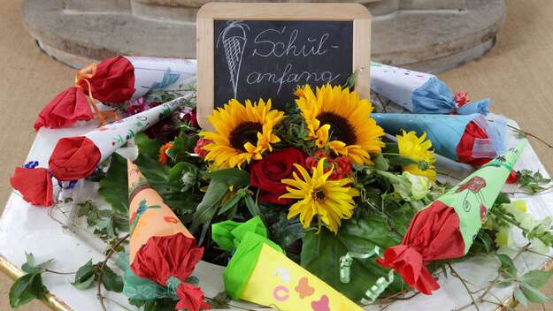 Einschulungsgottesdienst: Der Taufstein ist mit Blumen und Zuckertüten geschmückt