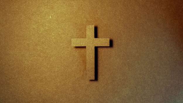 Braunes Kreuz auf einer braunen Wand Braunes Kreuz auf einer braunen Wand