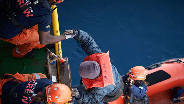 Rettung eines in Seenot geratenen Menschen aus einem Flüchtlingsboot