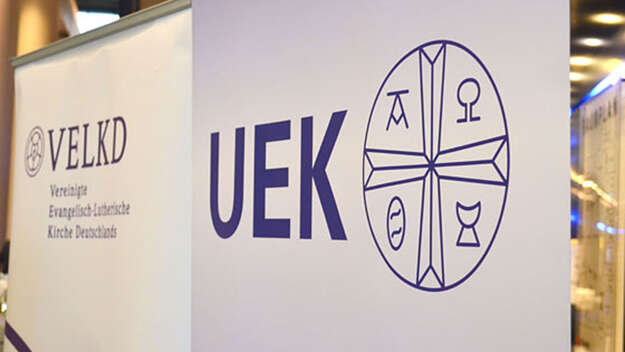 Foto mit Bannern der UEK und der VELKD
