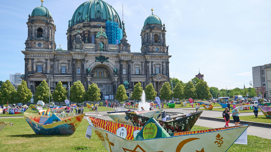 Mit einer Kunstaktion von der Arbeiterwohlfahrt AWO ist vor dem Berliner Dom am Donnerstag (20.06.2024) zum Weltfluechtlingstag an die mehr als 100 Millionen Menschen auf der Flucht erinnert worden. Dazu wurden im Lustgarten neben dem Dom rund 100 fuenf M