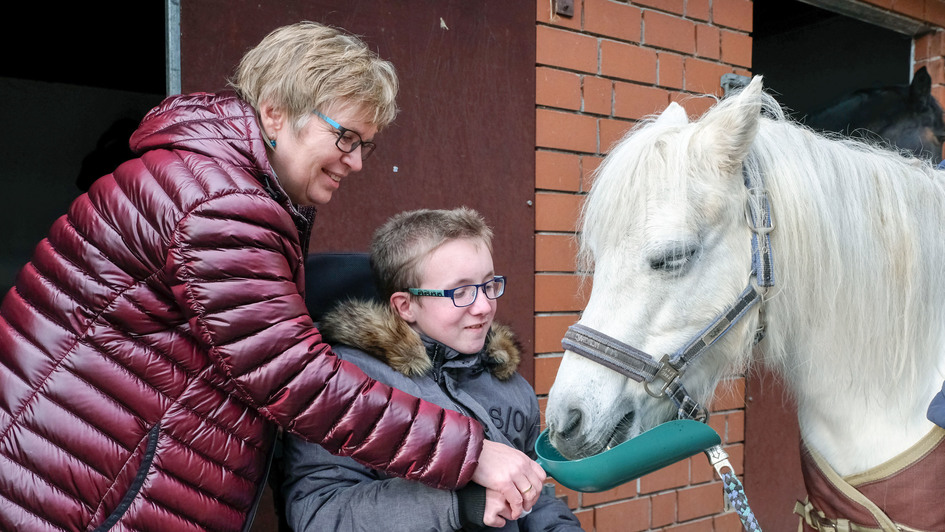 Evelyn Tegeler und der schwerkranke Timon Hagenlüke füttern ein Pferd