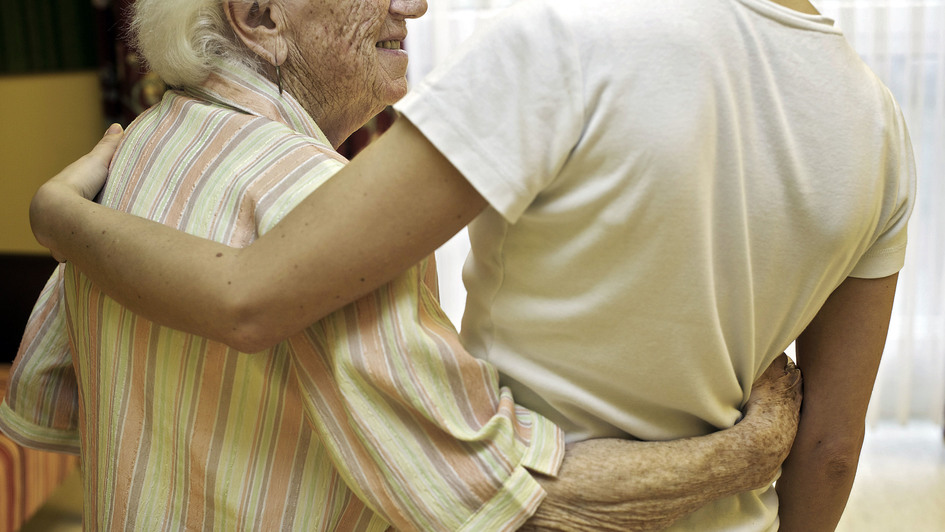 Ältere Frau umarmt junge Person
