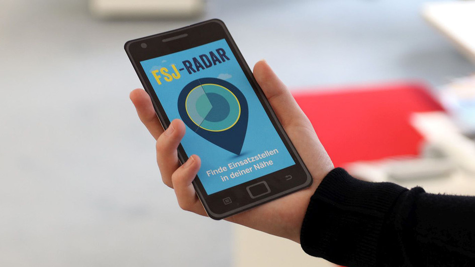 Frau hält Handy mit FSJ-Radar Frau hält Handy mit FSJ-Radar
