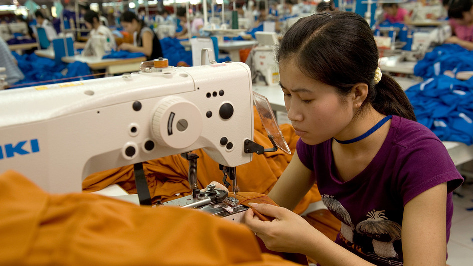 Arbeiterin näht an einer Maschine in einer Textilfabrik in Hung Yen/Vietnam