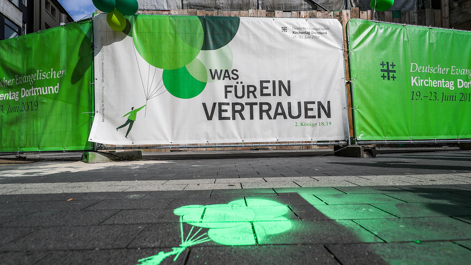 Verschiedene Plakate zum Kirchentag 2019 in Dortmund sind an Gitterwänden befestigt