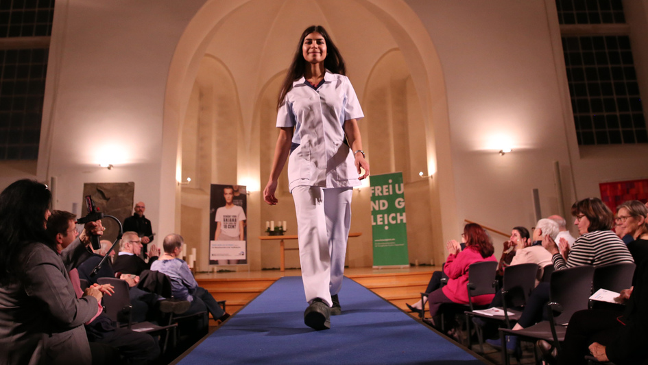 Modenschau beim Start der Menschenrechtskampagne zu fairer und gerechter Kleidung: Ein Model läuft in weißer Kleidung über einen Lauftsteg