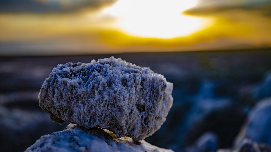 Stein mit Salzablagerungen vor Sonnenuntergang