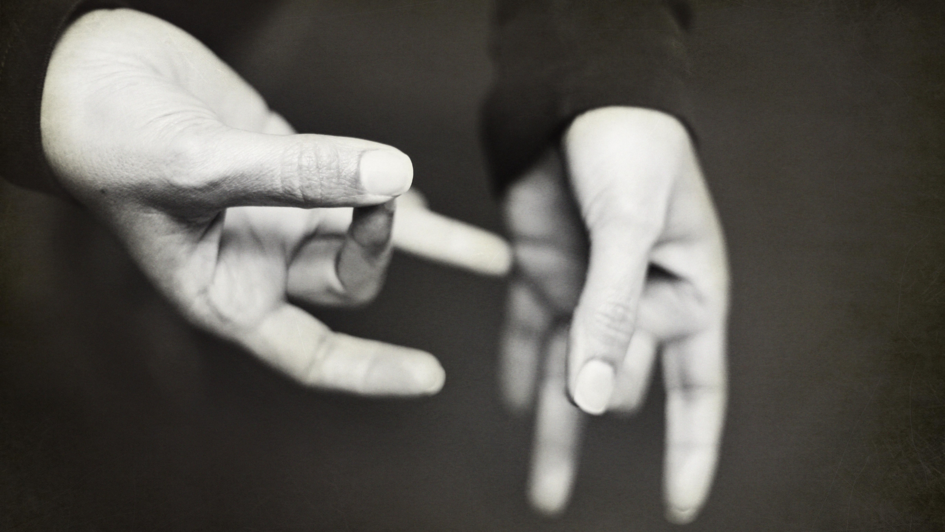 Schwarzweißfoto von zwei Händen, die Zeichen formen.
