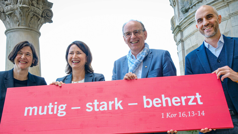 Gruppenfoto mit Losung v.l.n.r.: Generalsekretärin Kristin Jahn, Landesbischof Ralf Meister, Präsidentin Anja Siegesmund, Oberbürgermeister Belit Onay