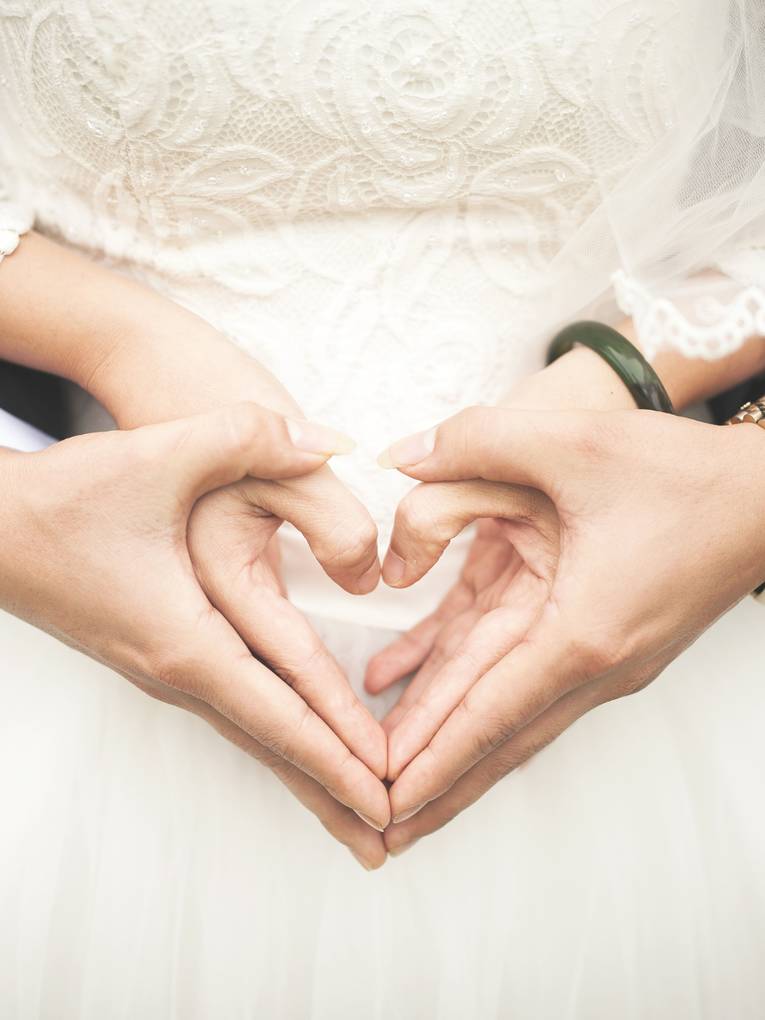 Braut und Bräutigam formen mit ihrem Händen ein Herz