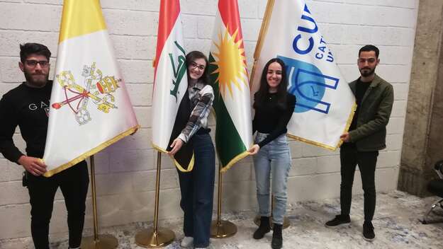 Rund 500 junge Frauen und Männer aus allen Ethnien und Religionen aus dem Irak studieren in Erbil. Studierende der Katholischen Universität in Erbil mit Flaggen in der Hand
