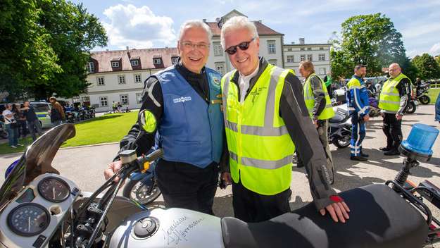 Der bayerische Innenminister Joachim Herrmann (CSU) und der EKD-Ratsvorsitzende Heinrich Bedford-Strohm mit einem Polizeimotorrad beim Abschluss der Spirit Tour 2019.
