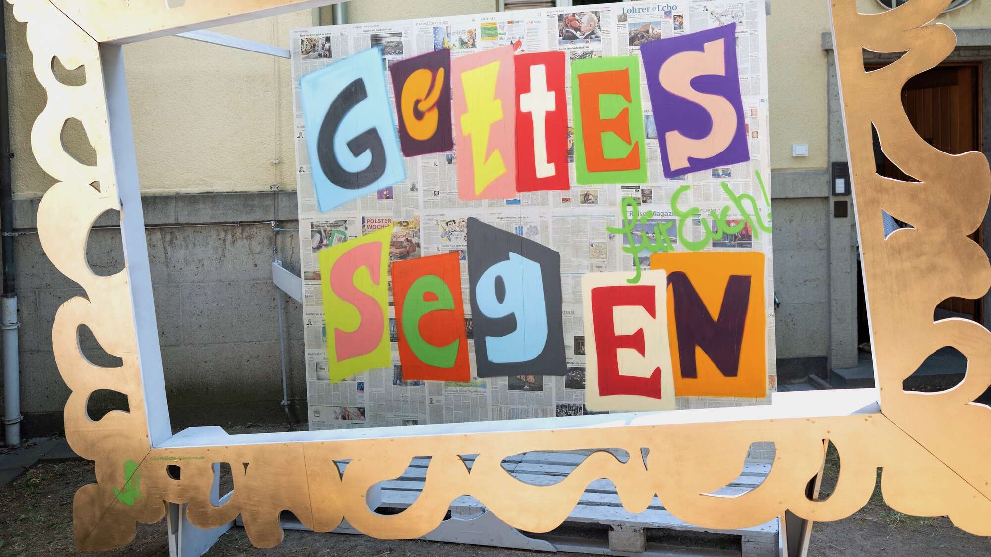 In einem goldenen Rahmen steht in bunten Buchstaben: 'Gottes Segen'